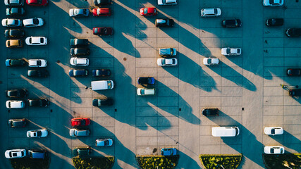 Parking w mieście pięknie oświetlony przez zachodzące słońce, światło-cień, ciekawy wzór geometryczny, ujęcie z drona