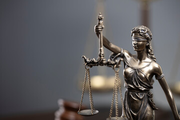 Law and justice concept. War crimes. Gavel, Themis sculpture and scale in lawyers office. Gray background.
