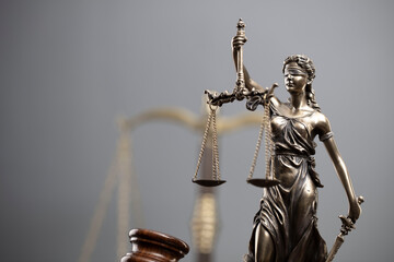 Law and justice concept. War crimes. Gavel, Themis sculpture and scale in lawyers office. Gray background.