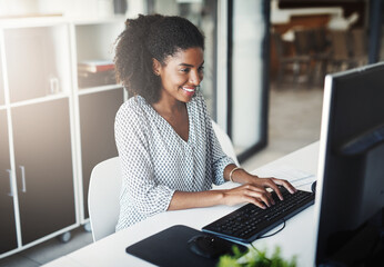 Shes always been a dedicated worker. Shot of a young businesswoman working on a computer in an...