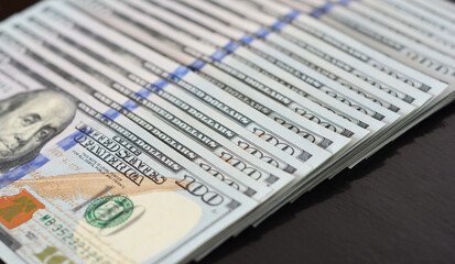 One hundred American dollars background. A row of one hundred dollar bills standing for US dollar exchange rate, money, earnings, or salary.