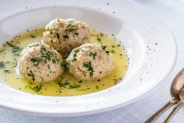 Boiled meatballs in dill sauce on white table
