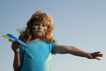 Close the sky over Ukraine banner. No fly zone over Ukraine. Sign of ukrainian flag on child cheek....
