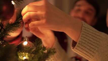 winter holidays and people concept - happy couple decorating christmas tree at home in evening - Powered by Adobe