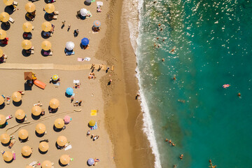 Ujęcie z drona na piękną plażę w Matala, na wyspie Kreta w Grecji, turkusowa woda i pomarańczowy piasek, rzędy parasoli plażowych - obrazy, fototapety, plakaty