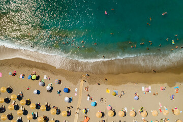 Ujęcie z drona na piękną plażę w Matala, na wyspie Kreta w Grecji, turkusowa woda i pomarańczowy piasek, rzędy parasoli plażowych - obrazy, fototapety, plakaty