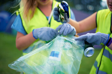 Cleaning up the aftermath of the festival. Cropped shot of two young women picking up trash after a...