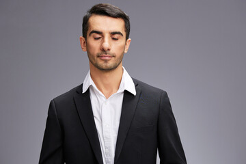 man with closed eyes in black business suit cropped view gray background copyspace