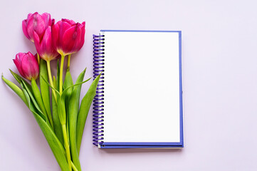 A beautiful bouquet of tulips and a notepad for text. The concept of spring flowers, romance, love.