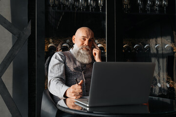 business owner of a liquor store sitting in front of an open laptop .