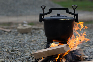 Garnek z duszącym się jedzeniem na otwartym ogniu, kuchnia tradycyjna. 