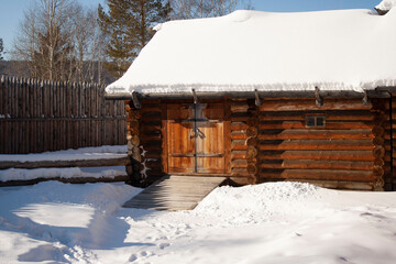 Wooden old country house winter snow on the roof of a snowdrift