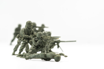 Plastic toy soldiers are arranged in a conflict situation and set against a white background. 