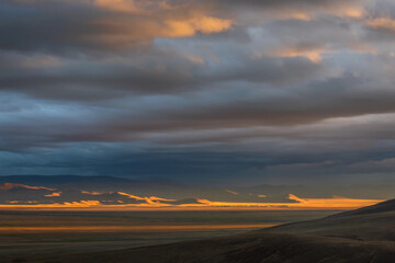 Fototapeta na wymiar steppe sunset mountains village sunlight rain clouds