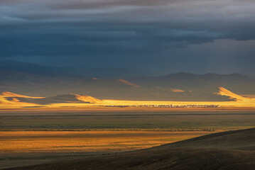 Fototapeta na wymiar steppe sunset mountains village sunlight rain clouds
