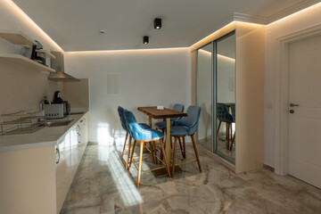 Interior of a modern new kitchen with dining table and chairs in the morning