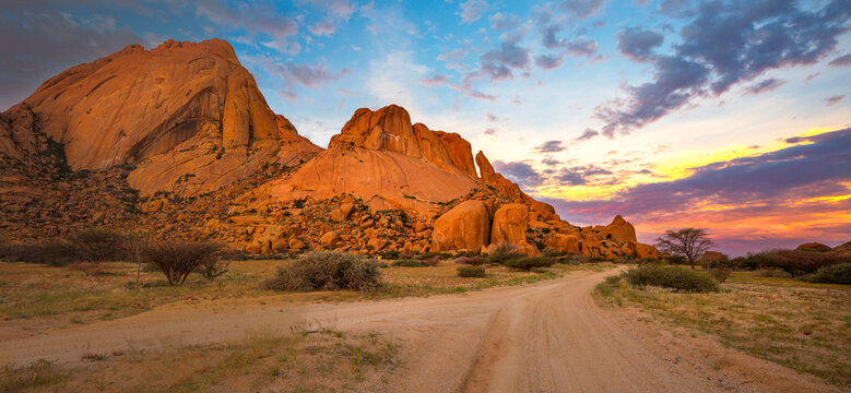 Granite rocks of Spitzkoppe with yellow and blue clouds at sunset
