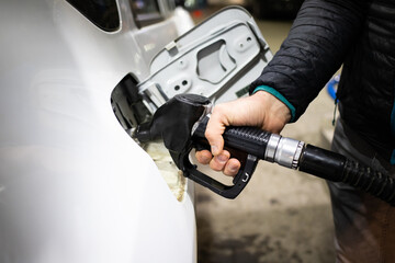 gas station putting gasoline into car oil price