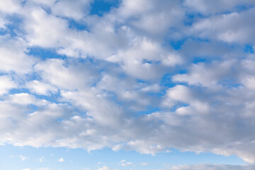 Naklejka na ściany i meble Stratocumulus white clouds at blue sky 