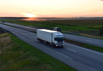 Obraz premium Freight truck. Truck with semi-trailer driving along highway. Goods delivery by roads. Services and Transport logistics. Lorry on delivery. Long Self-driving lorries. Shipping freight logistics.