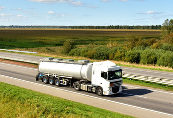 Isothermal Tank truck driving on highway. Oil and Gas Transportation and Logistics. Metal chrome...