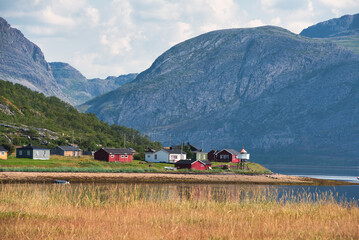 Colorful cottages in fjord landscape, Tanamunningen nature reserve in the mouth of the Teno aka Tana river, Finnmark, Norway