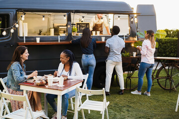 Multiracial people having fun eating at food truck restaurant outdoor - Focus on senior african...