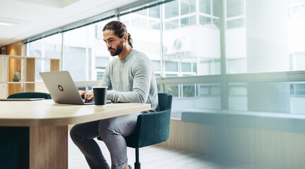 Businessman working on a laptop in a co-working space