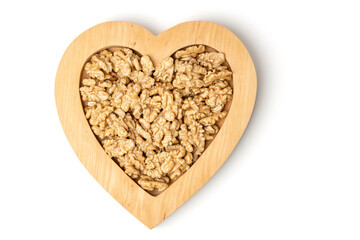 Walnut. Walnuts in a heart shaped wooden plate isolated on white background. Products for heart health. Copy space.