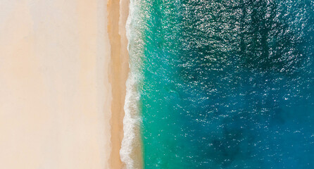 Fototapeta na wymiar Top-down aerial view of a clean white sandy beach on the shores of a beautiful turquoise sea