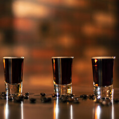 four alcohol coffee shot and coffee beans on the wooden table square