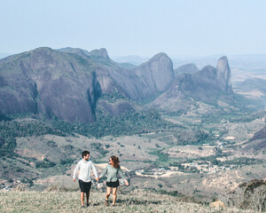 casal de mão dadas caminhando com montanhas ao fundo em Pancas, Espírito Santo