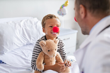 Hospitalized child in clown therapy with doctor