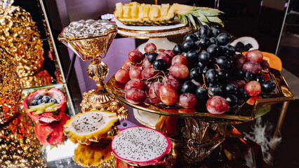 Fototapeta na wymiar Luxury candy bar on golden wedding. Candy bar decorated by flowers standing of festive table with deserts, and cakes, strawberry tartlet, cupcakes and macarons. Wedding. Reception Tartlets