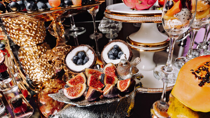 Luxury candy bar on golden wedding. Candy bar decorated by flowers standing of festive table with deserts, and cakes, strawberry tartlet, cupcakes and macarons. Wedding. Reception Tartlets