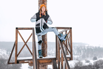 Beautiful girl at a winter resort with a snowboard and sunglasses
