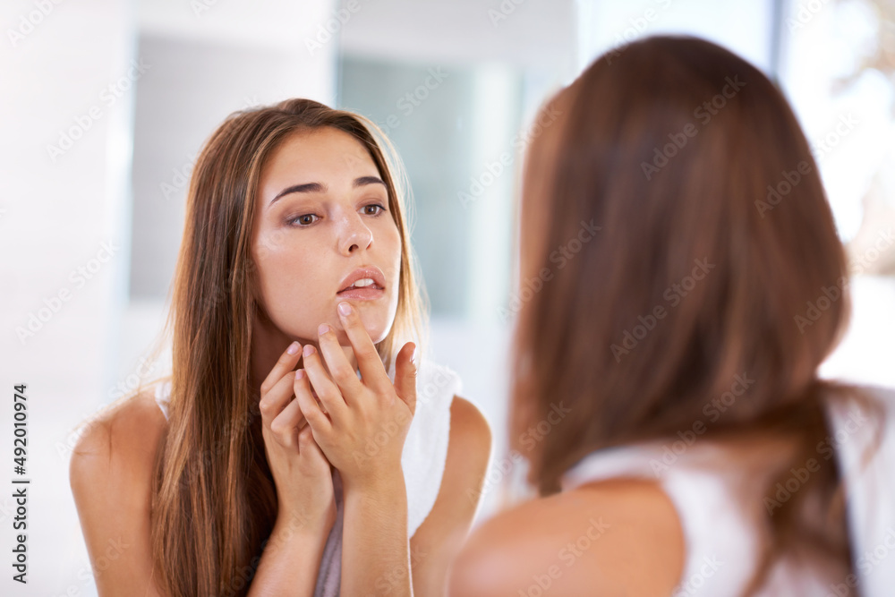 Canvas Prints Judging beauty. Over the shoulder shot of an attractive young woman looking at her reflection in a mirror.