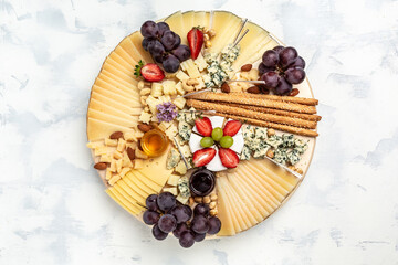 Cheese variety board or platter with cheese assortment, grapes, honey and nuts. aperitivo party concept, banner, menu, recipe place for text