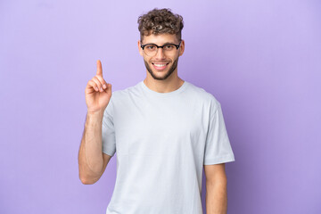 Delivery caucasian man isolated on purple background pointing up a great idea