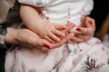 Baby holding mother's hand stock photo.