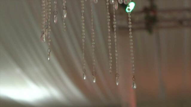 Disco lights reflecting on chandelier decor, indoor event wedding, closeup