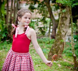 Beautiful little girl holding a big color shaped lollipop