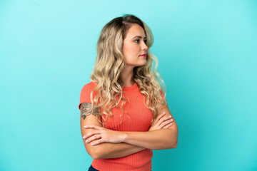 Young Brazilian woman isolated on blue background looking to the side