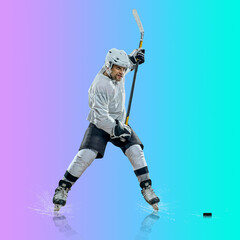 Professional ice hockey player hitting puck for winning goal in action on gradient multicolored...