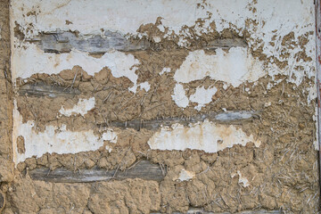 Sunja, Croatia, April 20,2021 : Facade of mud and straw on old wooden house.