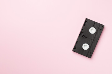 Old analog tape VHS cassette on color background, top view