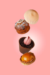 cakes with icing and nuts fly on a pink background