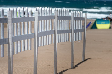 Selective focus of a wooden fence on the beach with the sea in the background