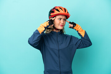 Young cyclist woman isolated on blue background having doubts and thinking