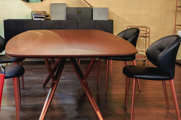 Wooden oval table with black leather chairs